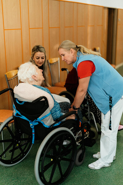 Caregiver speaking with an older adult in a wheelchair
