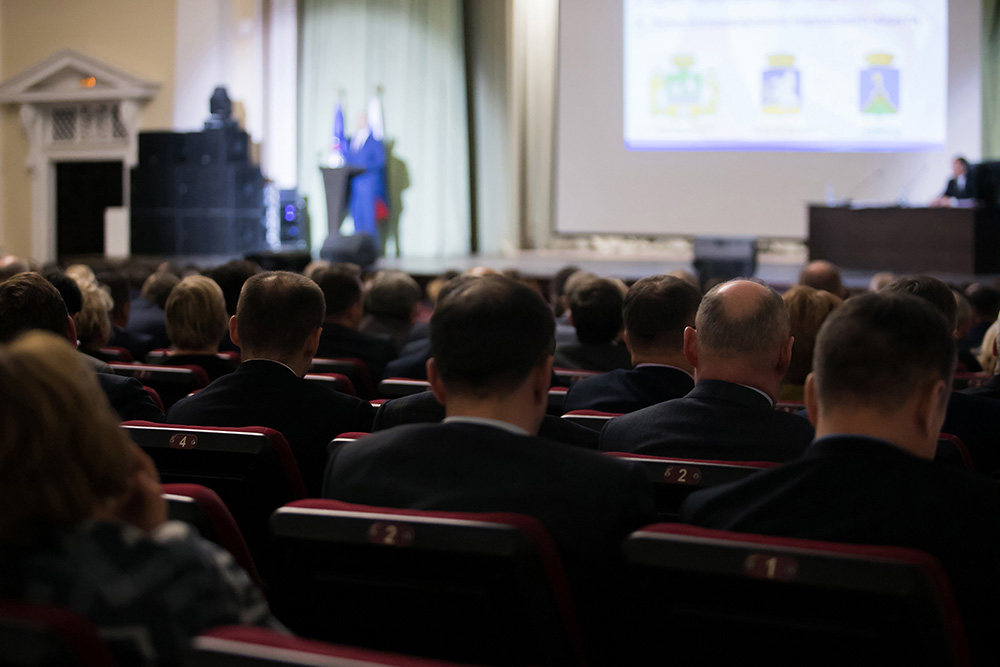 room of audience members listening to a speaker