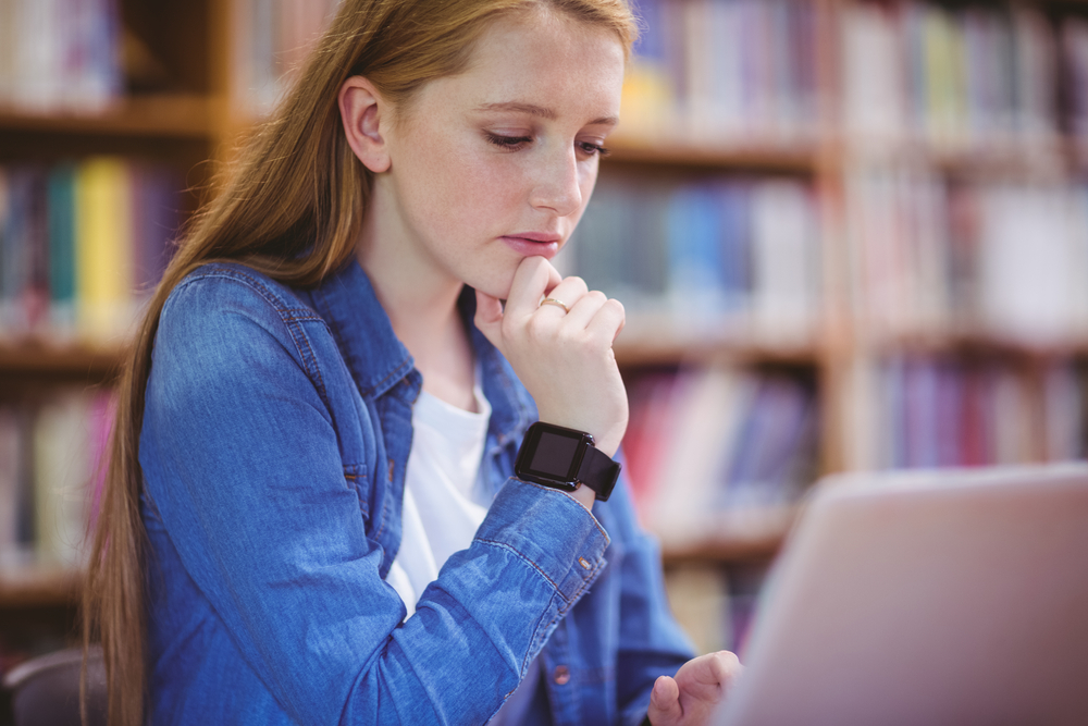 Student working on laptop in a library