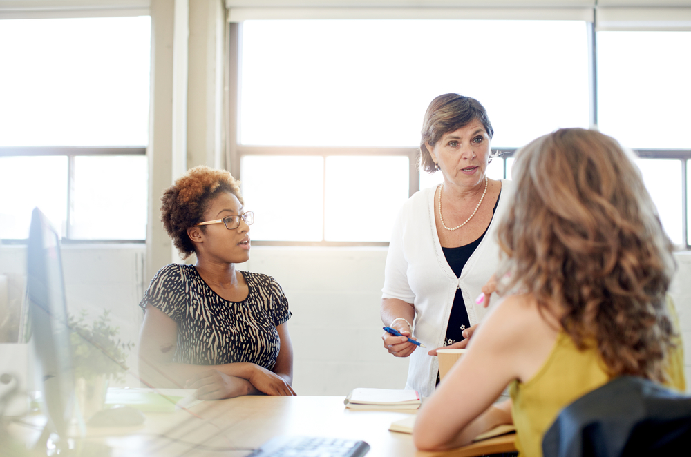 Unposed group of creative business people in an open concept office brainstorming their next project.-1