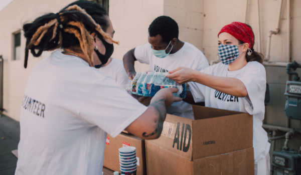 Volunteers working on sorting items in a cardboard box