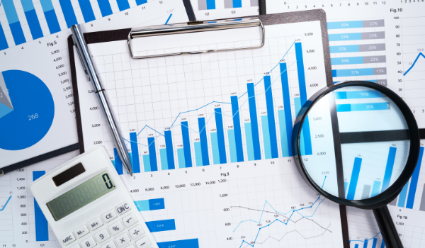 Accounting spreadsheets with a calculator and magnifying glass on top